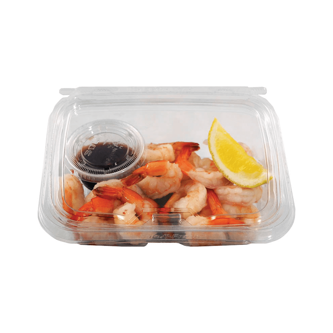 Cooked shrimp with lemon and sauce in a clear plastic container.