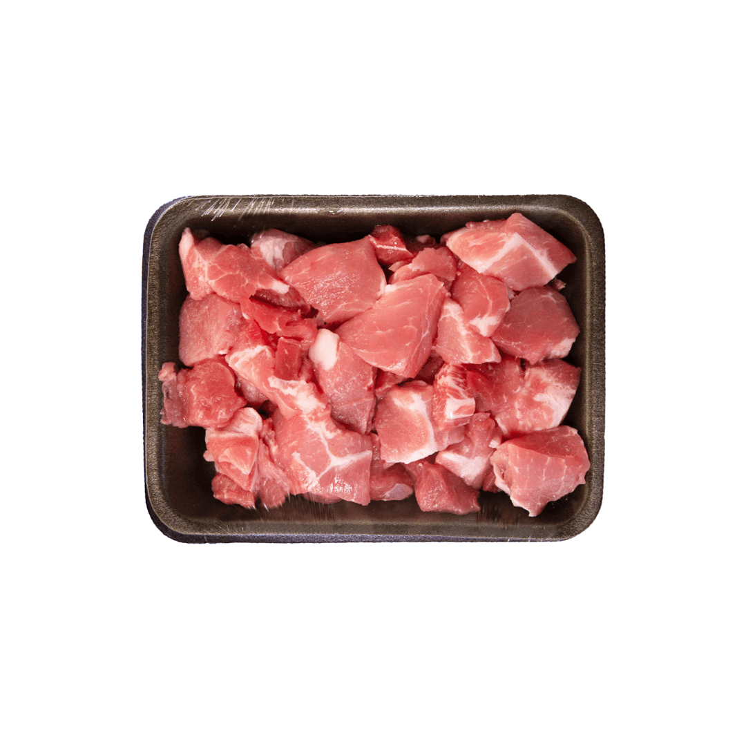 Cubed raw pork in a black tray, isolated on white.